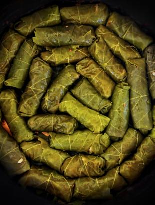 Παραδοσιακά κουπέπια με φύλλα αμπελιού και λαχανόφυλλα κατά την τοποθέτησή τους για ψήσιμο, Ξυλοτύμπου 2014. &lt;br/&gt; Πηγή: Χαράλαμπος Παρασκευά.