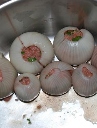 Τα γεμιστά κρεμμύδια τοποθετούνται στην κατσαρόλα για ψήσιμο. &lt;br/&gt; Πηγή: Γ. Γρούτας.