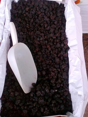 Μαύρες, μεγάλες σταφίδες σε κασόνι, προς πώληση.