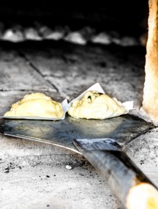 Τοποθετώντας τις φλαούνες στον παραδοσιακό φούρνο, Μένοικο 2014.<br/> Πηγή: Παναγιώτης Γεωργίου.