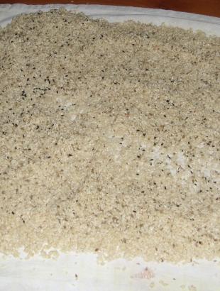 2. Απλώνουμε σε μια πετσέτα το σησάμι, πάνω στο οποίο τοποθετούμε τις πίτες.