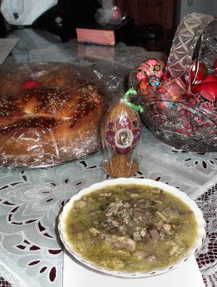 Ελληνικό πασχαλινό τραπέζι με τσουρέκι, κόκκινα αυγά και μαγειρίτσα.