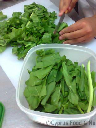 Τα λάχανα κόβονται για να προστεθούν στη συνταγή (Μαγειρεύω Κυπριακά 2014). &lt;br/&gt; Πηγή: Στάλω Λαζάρου.