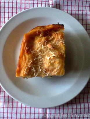 Κομμάτι μακαρόνια του φούρνου. Η μπεσαμέλ πασπαλίζεται με τριμμένο χαλλούμι ή αναρή.