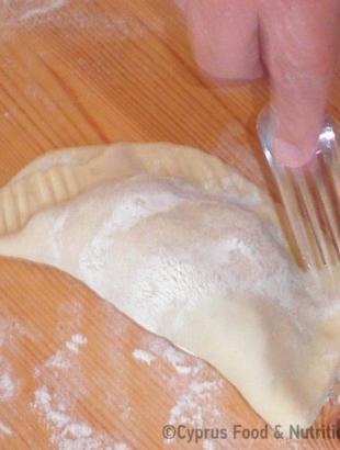 11. Διπλώνουμε την πιτούλα και κλείνουμε τη γέμιση. Πηρουνιάζουμε γύρω-γύρω. &lt;br/&gt; Πηγή: Ζηνοβία Χαραλάμπους.