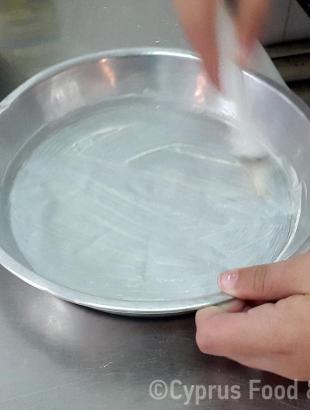 Βουτυρώνουμε το ταψί μας (Μαγειρεύω Κυπριακά 2015). &lt;br/&gt; Πηγή: Στάλω Λαζάρου.