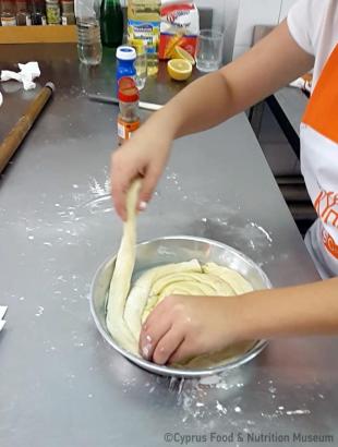 Το τοποθετούμε κυκλικά στο ταψί μας (Μαγειρεύω Κυπριακά 2015). &lt;br/&gt; Πηγή: Στάλω Λαζάρου.