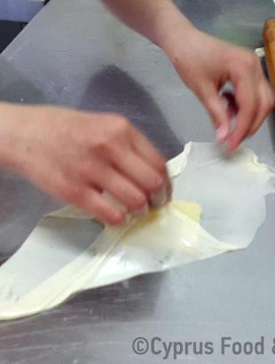 Αφού τοποθετηθεί η γέμιση στο λεπτό φύλλο, οι άκρες του διπλώνονται  ανά δύο διαγώνια στο κέντρο (Μαγειρεύω Κυπριακά 2015). &lt;br/&gt; Πηγή: Στάλω Λαζάρου.