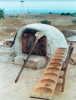 Παραδοσιακός φούρνος μαζί με τα απαραίτητα σύνεργα για το φούρνισμα των ψωμιών: φουρνόφτυαρο στα αριστερά και κουπποσάνιδο ή γουπποσάνιδο στα δεξιά.