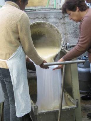 Παρασκευή πίσσας στη Γεροσκήπου. Έχουν χοχλάσει την πίσσα και τη χύνουν σε σακούλι για τελικό καθαρισμό. Φωτ. Γ. Γαβριήλ, 2005.