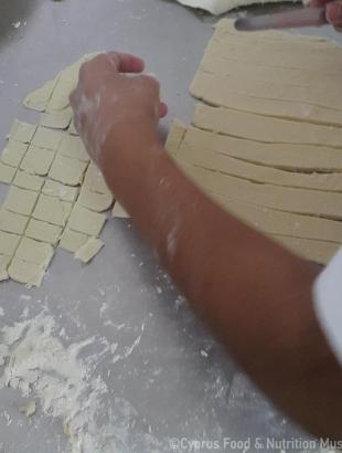 Το φύλλο ζύμης κόβεται σε ορθογώνια κομμάτια, τα τουμάτσια. Μαγειρεύω Κυπριακά 2015.