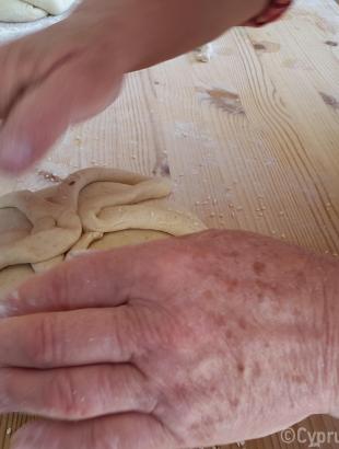 Διακόσμηση της γεννόπιττας. Με λωρίδα ζυμαριού σχηματίζεται σταυρός ή τετράφυλλη μαργαρίτα. Λετύμπου 2016.