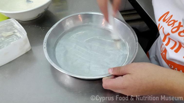 Βουτυρώνουμε το ταψί μας (Μαγειρεύω Κυπριακά 2015). <br/> Πηγή: Στάλω Λαζάρου. 