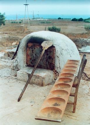 Παραδοσιακός φούρνος μαζί με τα απαραίτητα σύνεργα για το φούρνισμα των ψωμιών: φουρνόφτυαρο στα αριστερά και κουπποσάνιδο ή γουπποσάνιδο στα δεξιά.  <br/> Άδεια δημοσίευσης: Υπουργείο Γεωργίας. 